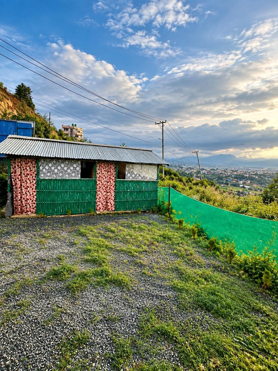 Green bamboo hut with the city in the valley below