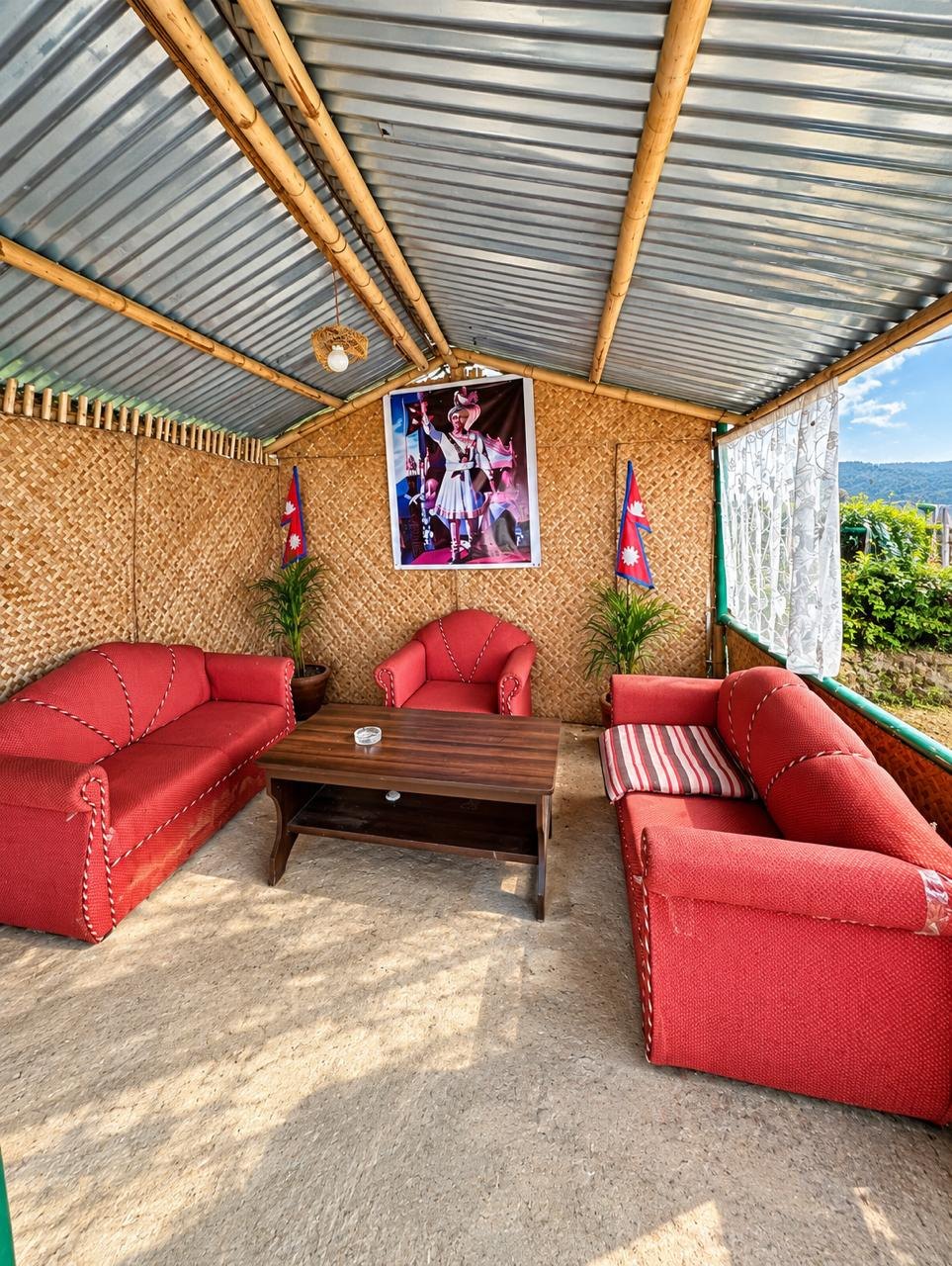 Red sofas around a coffee table in the covered lounge